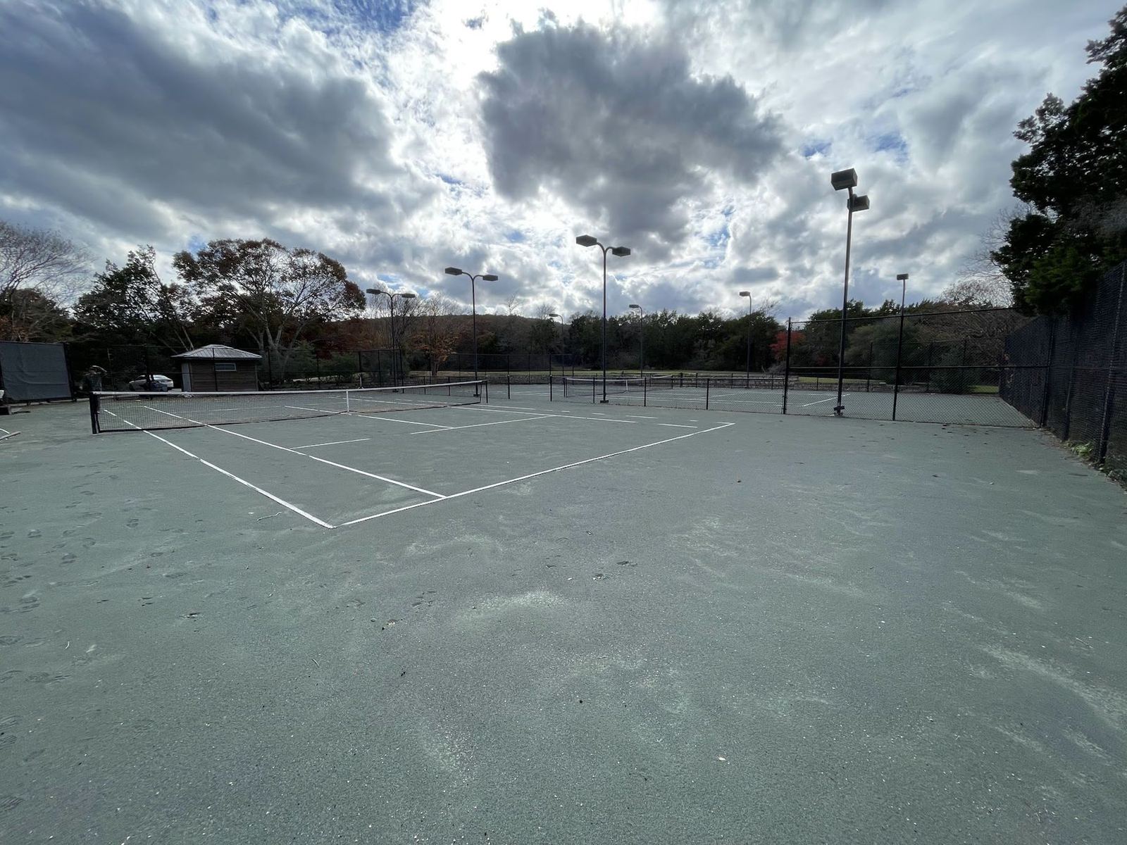 The cracked tennis court on the same site before construction